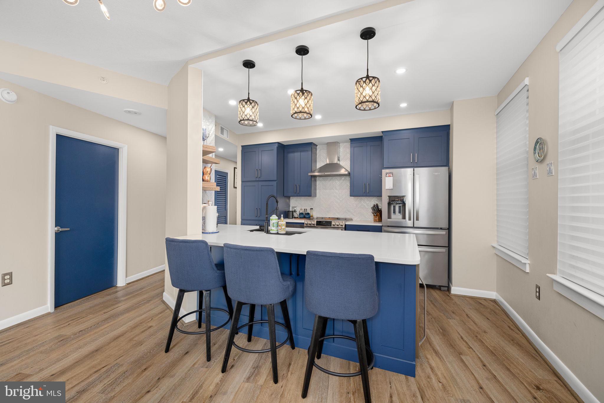 400 Massachusetts Avenue Northwest, Unit 1011 Washington, DC 20001 - Photo 10 of 31 a kitchen with stainless steel appliances a dining table chairs and wooden floor