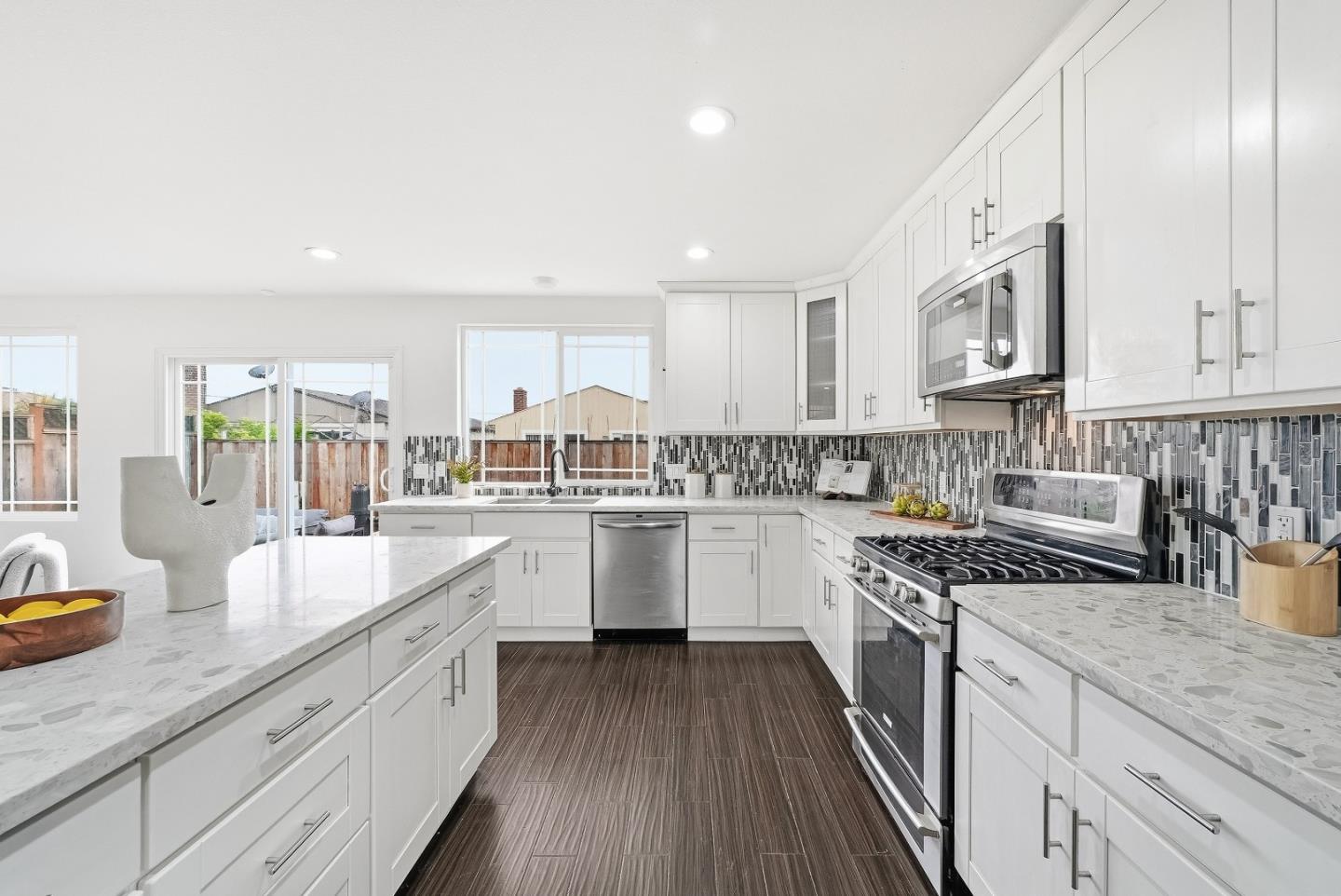 36045 Haley Street Newark, CA 94560 - Photo 12 of 38 a kitchen with granite countertop white cabinets and white appliances