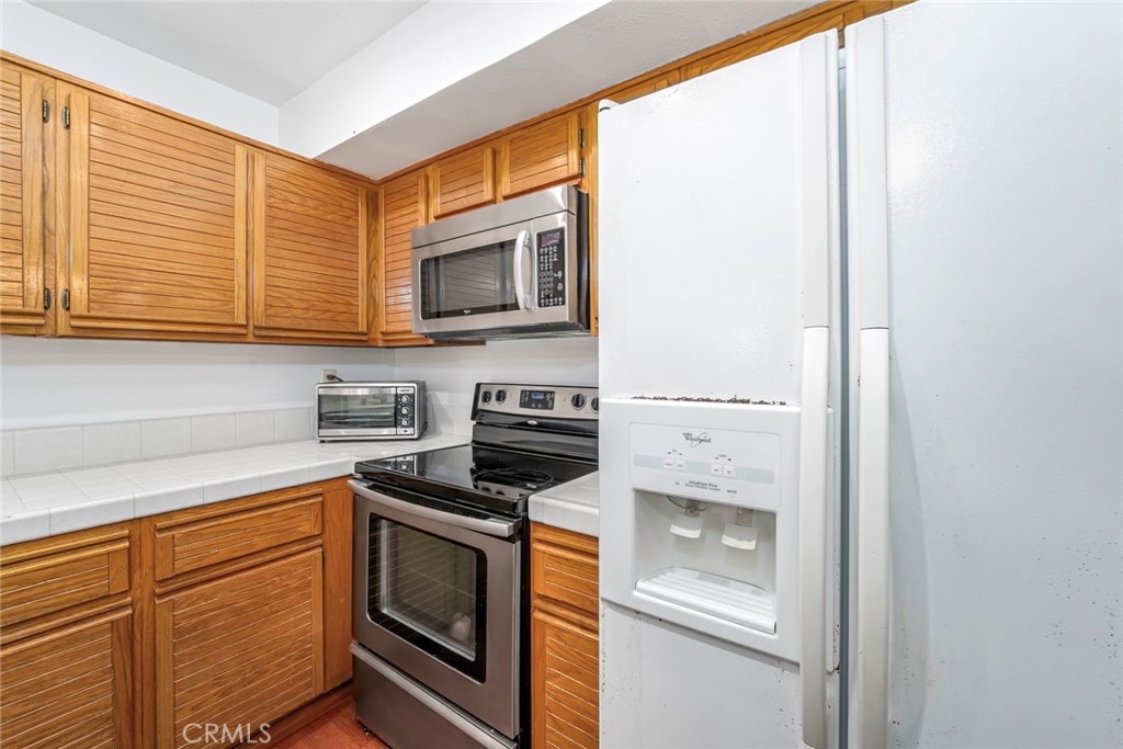 25712 Le Parc, Unit 48 Lake Forest, CA 92630 - Photo 11 of 30 a kitchen with stainless steel appliances a stove microwave and cabinets