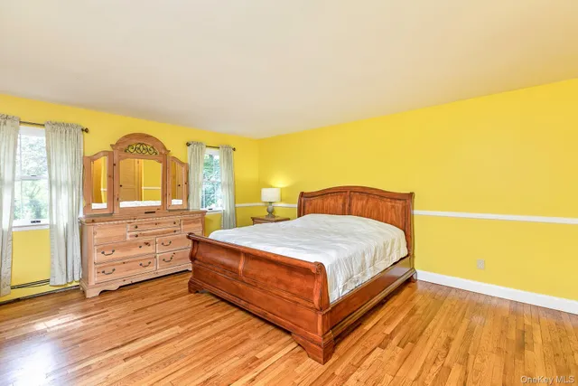 a spacious bedroom with a bed and wooden floor