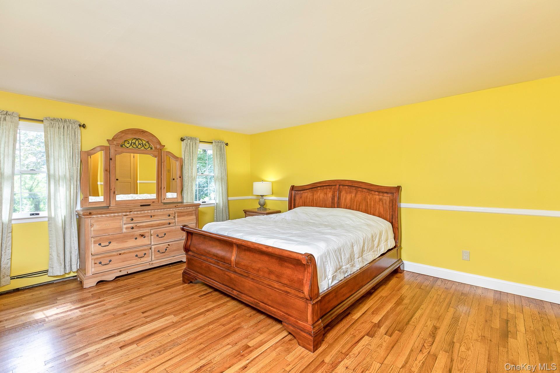 451 River Road St. James, NY 11780 - Photo 15 of 26 a spacious bedroom with a bed and wooden floor