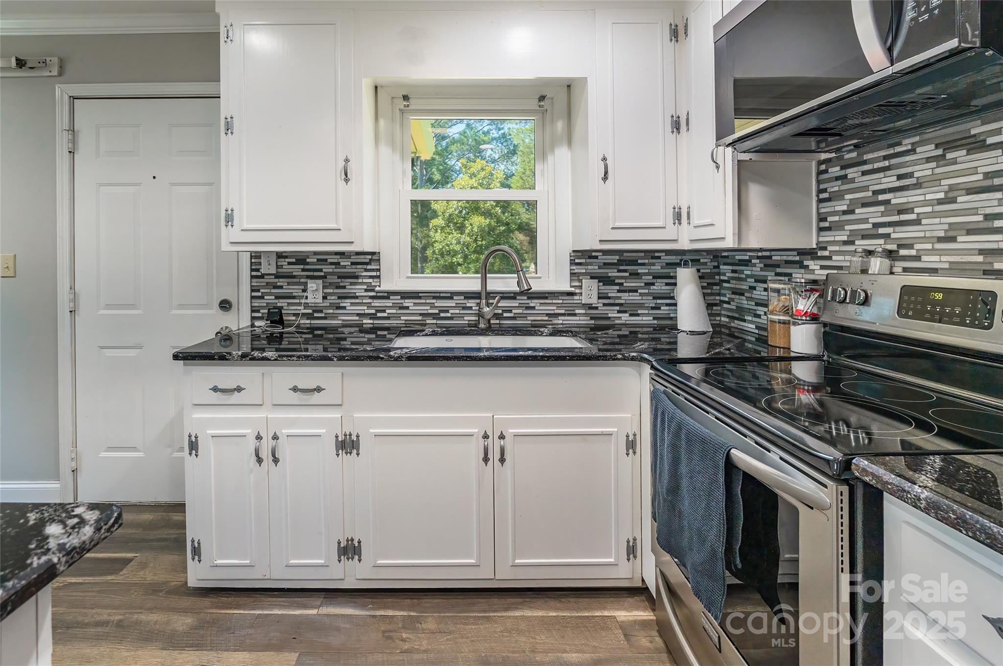 111 Berry Street Chester, SC 29706 - Photo 6 of 23 a kitchen with granite countertop white cabinets and white appliances