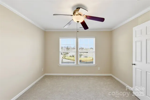 an empty room with window and ceiling fan