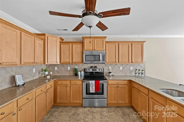 a kitchen with stainless steel appliances a stove sink microwave and cabinets
