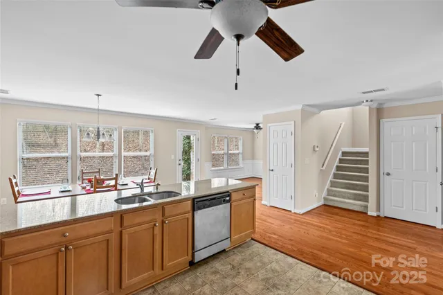 a open kitchen with granite countertop a stove a sink and wooden floors
