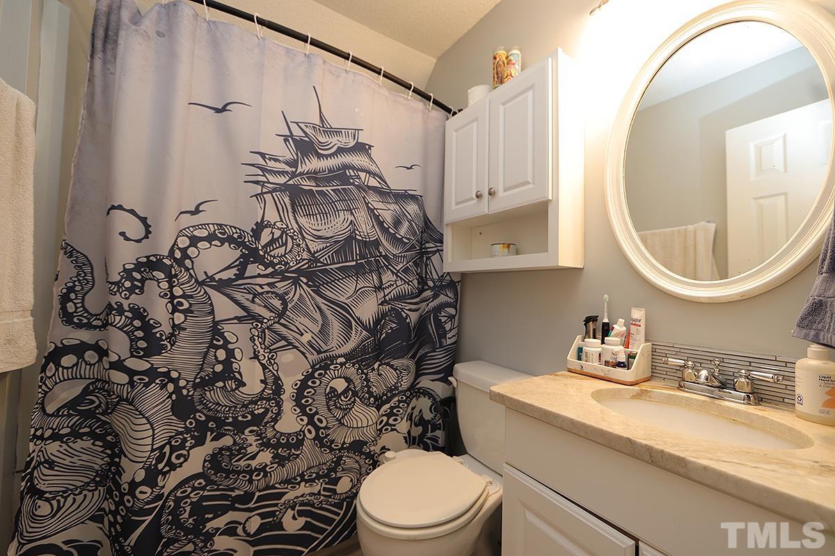 3301 East Jameson Road Raleigh, NC 27604 - Photo 20 of 29 a bathroom with a sink a toilet and a mirror