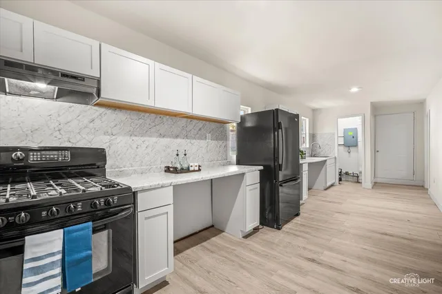 a kitchen with a stove a refrigerator and cabinets