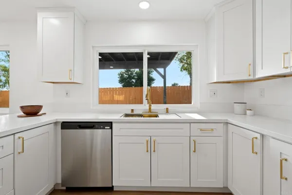 a kitchen with white cabinets and sink