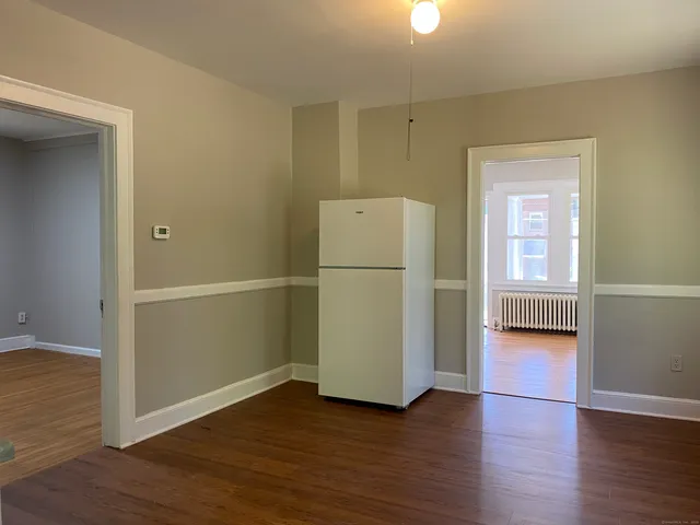 a view of a kitchen with wooden floor and a refrigerator