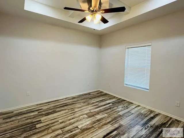 an empty room with a window and ceiling fan
