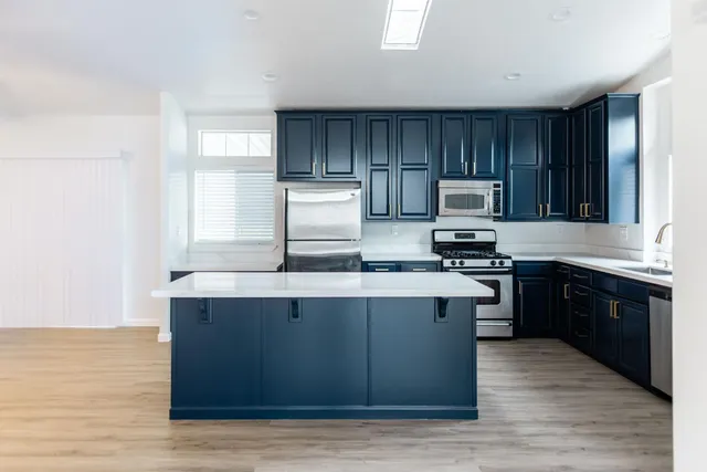 a kitchen with granite countertop wood cabinets and a stove top oven