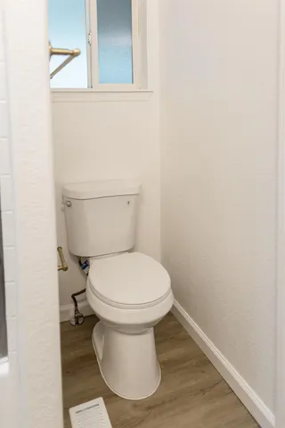 a white toilet sitting next to a shower