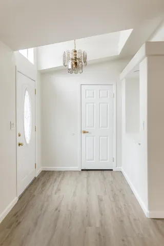 an empty room with wooden floor fireplace cabinet and windows