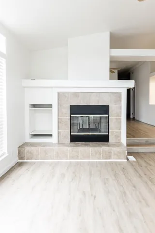 a kitchen with stainless steel appliances granite countertop a stove a sink dishwasher and a microwave oven on the wooden floor