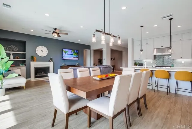 a kitchen with stainless steel appliances granite countertop a sink a stove a refrigerator and island with wooden floor