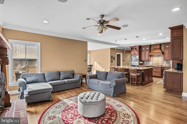 a open kitchen with stainless steel appliances granite countertop a kitchen island a stove a table and chairs