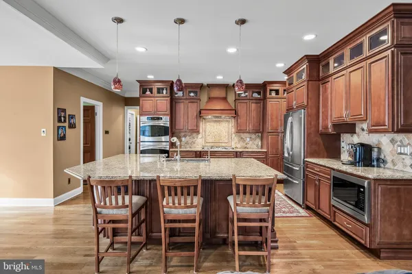 a kitchen with stainless steel appliances granite countertop a stove top oven a sink and a refrigerator