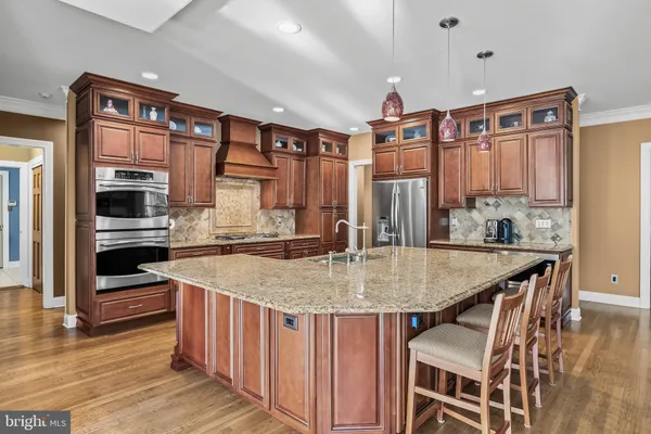 a kitchen with stainless steel appliances granite countertop a refrigerator and a stove top oven