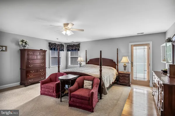 a bedroom with a bed a chandelier and dresser