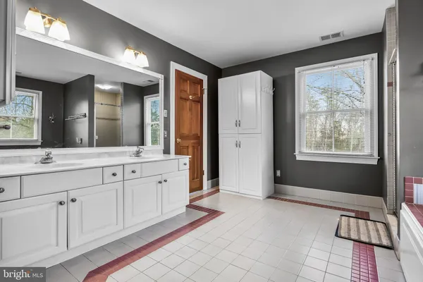 a bathroom with a tub sink and mirror