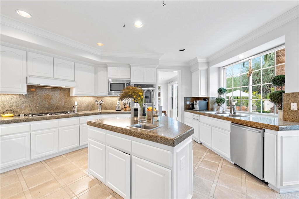 1 Meryton Irvine, CA 92603 - Photo 10 of 42 a kitchen with granite countertop white cabinets and white appliances