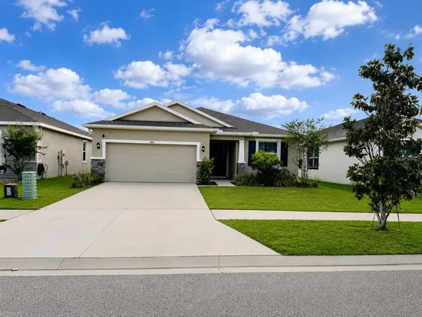 a front view of a house with a yard and garage