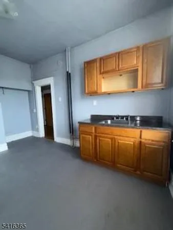a kitchen with granite countertop a sink and cabinets