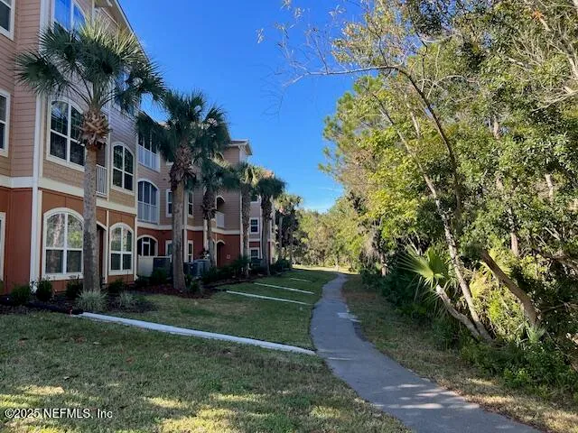 a view of a big building with a big yard and large trees