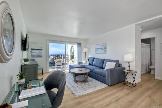 a living room with furniture a large window and a chandelier