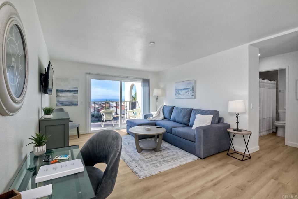 6675 Paseo Del Norte, Unit B Carlsbad, CA 92011 - Photo 3 of 19 a living room with furniture a large window and a chandelier