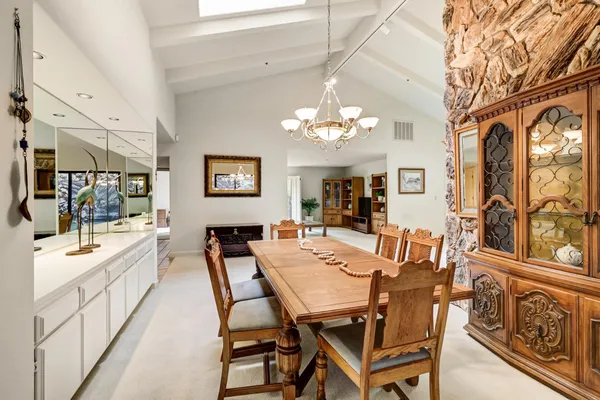 a view of a dining room with furniture a chandelier and wooden floor