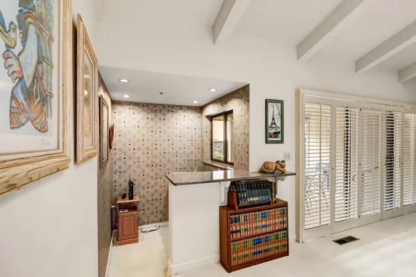 a front view of a house with a yard and potted plants