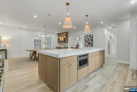 a kitchen with center island wooden floor and a chandelier