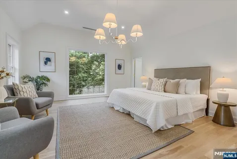 a spacious bedroom with a bed and a chandelier