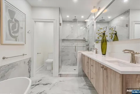 a bathroom with a tub sink and mirror