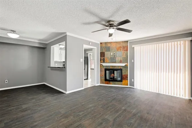 an empty room with windows fireplace and wooden floor