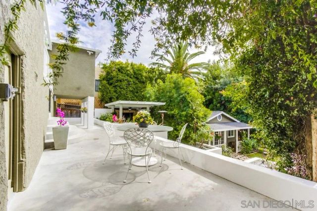 a view of a patio with a table and chairs under an umbrella