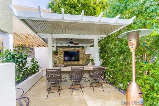 a view of a white house with large windows and a table and chairs