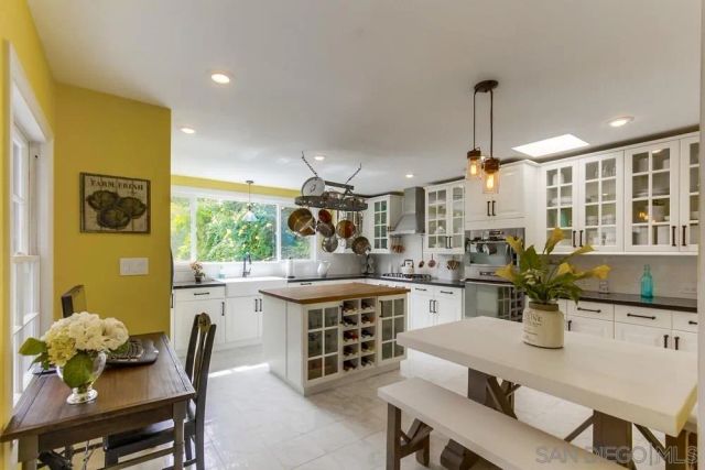 a kitchen with a stove a sink a dining table and chairs