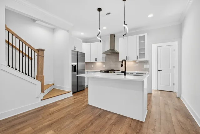 a kitchen with kitchen island a sink and wooden floor