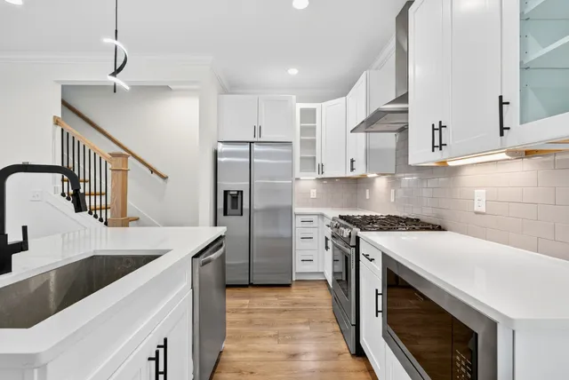 a kitchen with stainless steel appliances granite countertop a sink stove and refrigerator