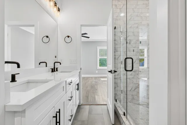 a spacious bathroom with a double vanity sink a mirror a shower and a bathtub