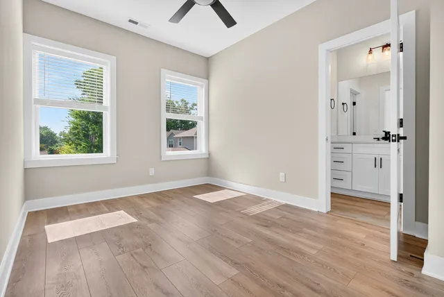 an empty room with wooden floor and windows