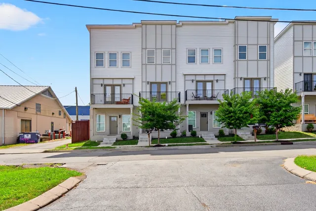 a front view of a building with a garden and plants