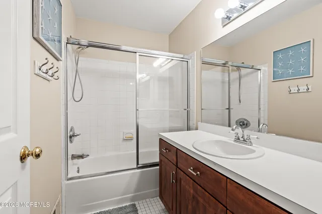 a bathroom with a shower sink and mirror