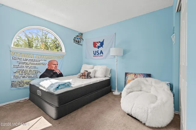 a bedroom with a bed and a painting on the wall