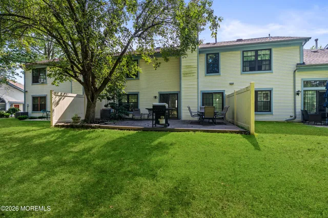 a view of a house with a backyard and a tree