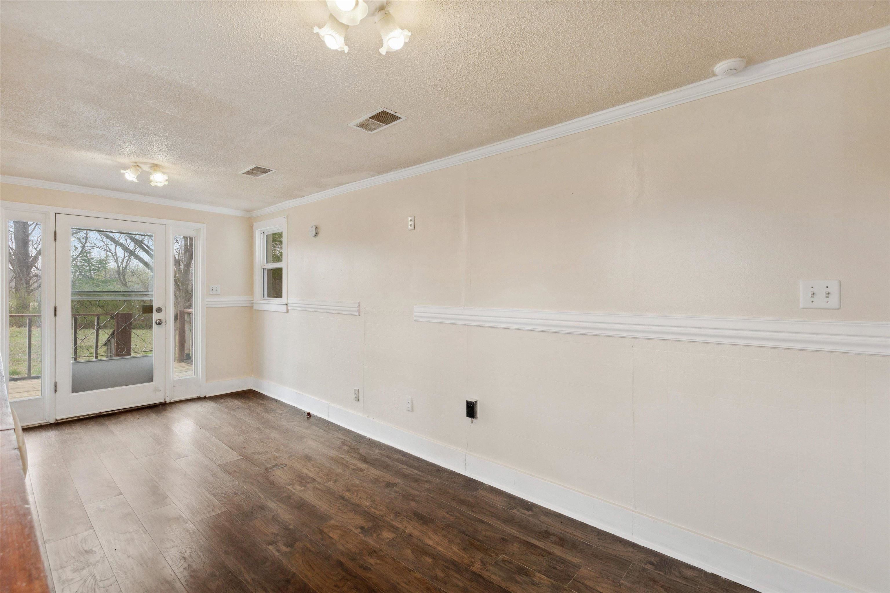 8457 East Kerrville Rosemark Road Millington, TN 38053 - Photo 13 of 25 Empty room featuring dark wood-style floors, ornamental molding, and a textured ceiling