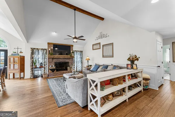 a kitchen with stainless steel appliances a dining table chairs stove refrigerator and cabinets