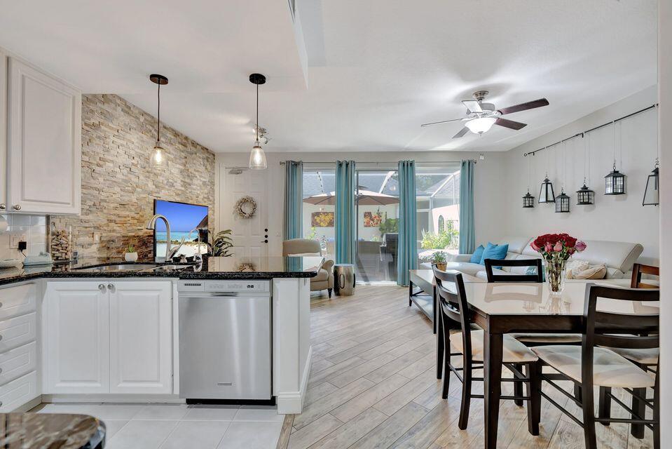 180 Freeport Drive Jupiter, FL 33458 - Photo 18 of 58 a kitchen with granite countertop a dining table chairs sink and cabinets